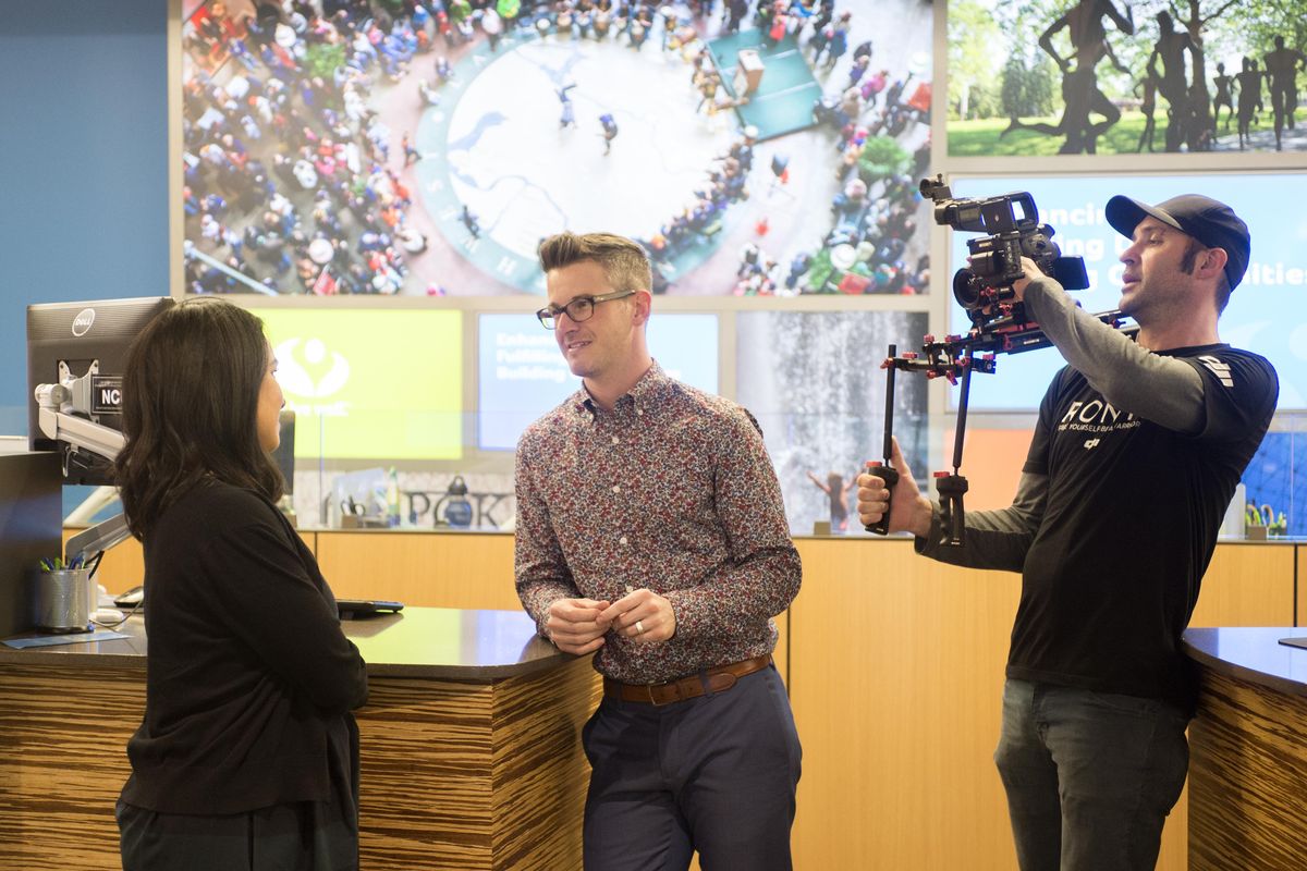 Photographer Jeremy Kaynor, right, films a conversation between TV personality Natali Morris, left, and Jake Krummel,  of Numerica Credit Union, on Monday in Spokane. Lifetime Television has partnered with Numerica to do a money makeover of a Spokane couple on a reality show that will be shot this week, then broadcast in August. (Jesse Tinsley / The Spokesman-Review)