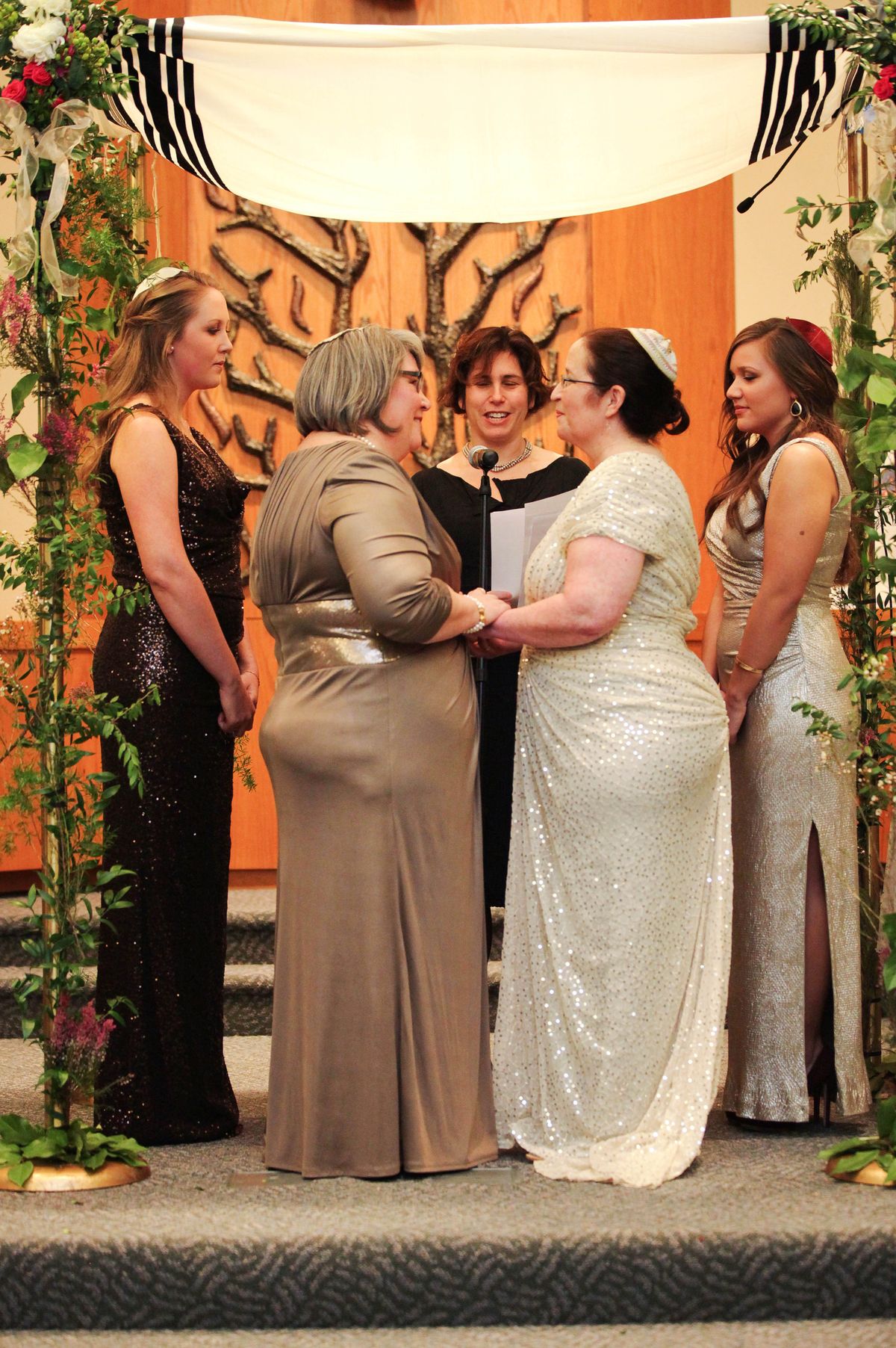 Shelly Crocker, second from left, and Sandy Kibort, second from right, with Rabbi Jill Borodin, center, during their wedding, with their daughters, Emma Kibort-Crocker, left, and Hannah Kibort-Crocker, right, at Congregation Beth Shalom in Seattle. (Associated Press)