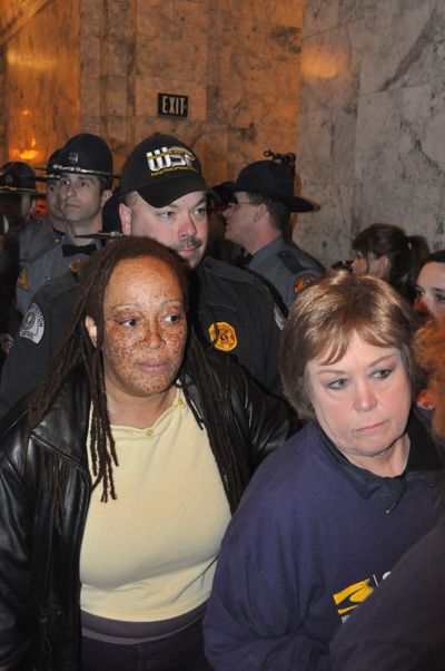 Karen Washington, left, of Spokane is among protesters arrested by the Washington State Patrol outside the governor's office on Thursday, April 7.