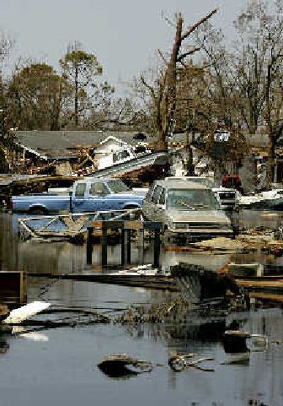 
Vehicles, boats and debris lie against damaged homes in a pool of oil and water in Port Sulphur, La. on the Mississippi River. 
 (Associated Press / The Spokesman-Review)