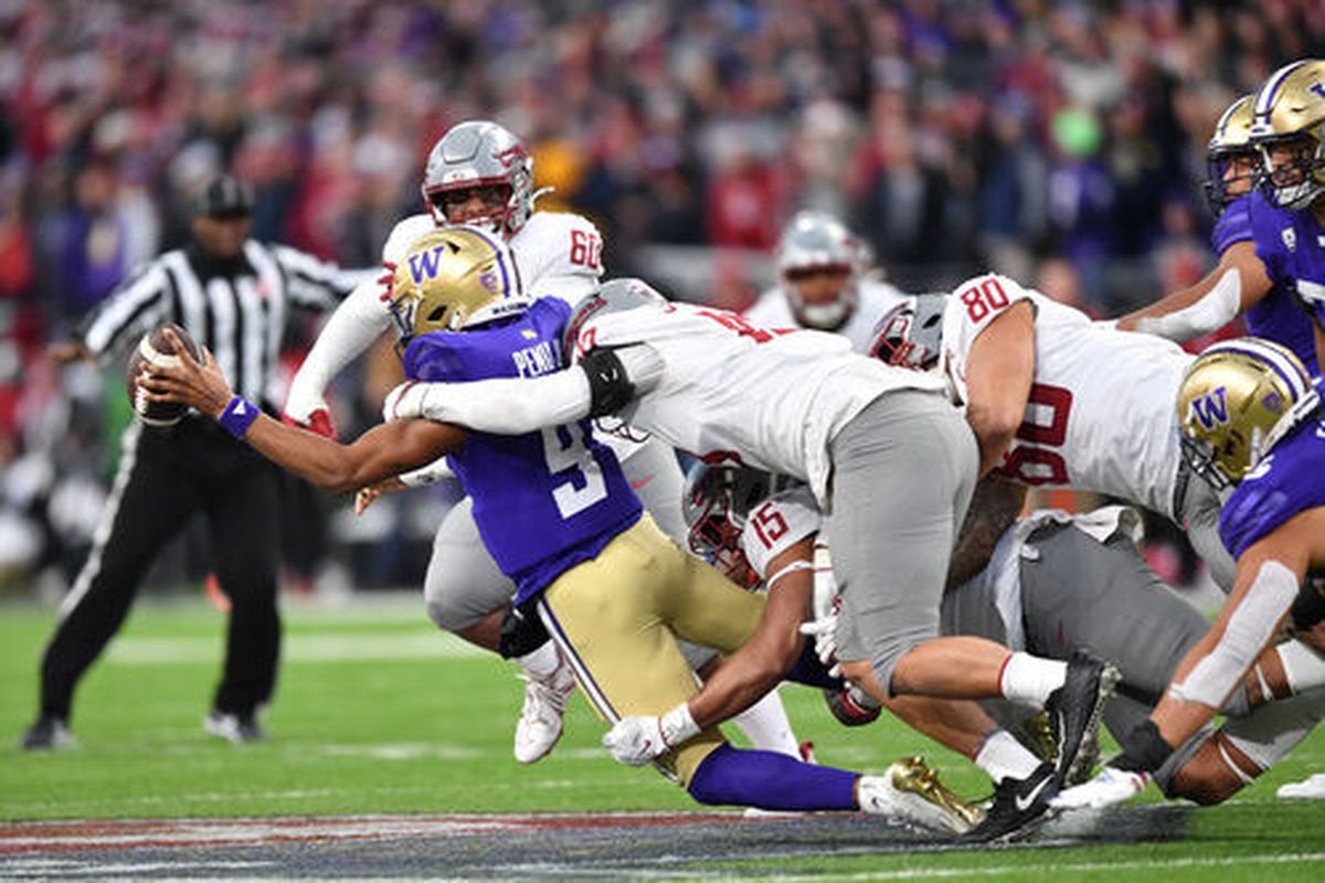 Washington State’s defense wraps up Washington quarterback Michael Penix Jr. for a sack during the second half of Saturday’s game at Husky Stadium in Seattle.  (Tyler Tjomsland / The Spokesman-Review)