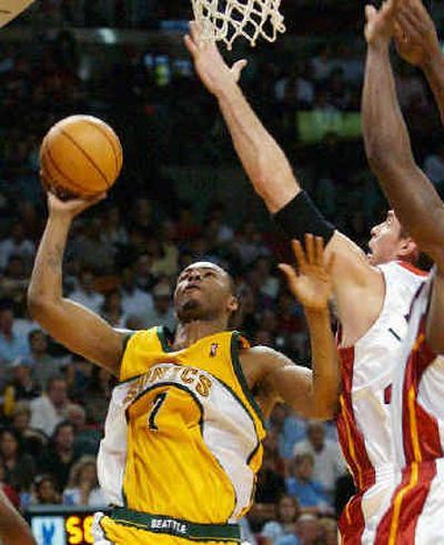 Seattle's Rashard Lewis scores two of his 17 points over Christian Laettner.
(Associated Press / The Spokesman-Review)