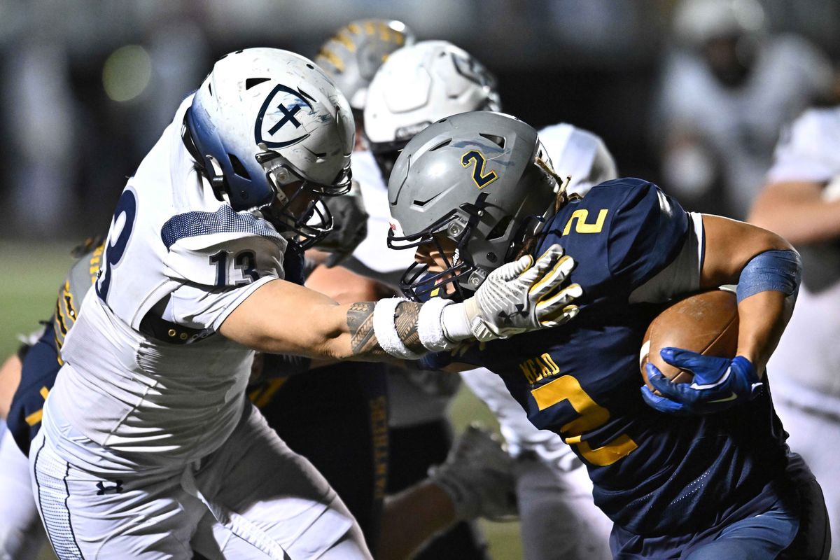 Mead running back Max Faagau is brought down by Gonzaga Prep defender Nehemiah Areta during a GSL game on Oct. 24.  (James Snook/The Spokesman-Review)