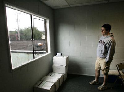 
Peter McCollum, statewide signature drive coordinator for Healthy Indoor Air for All Washington, the backers of Initiative 901, looks at the recently repaired window at the group's offices in Seattle on Tuesday. 
 (Associated Press / The Spokesman-Review)