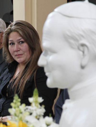 Costa Rica’s Floribeth Mora looks at a bust of Pope John Paul II while giving her account of a miracle attributed to him. (Associated Press)