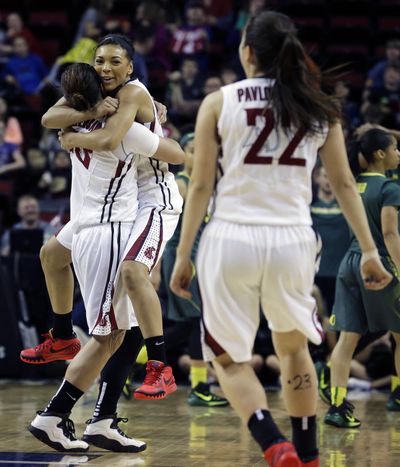 Washington State's Lia Galdeira, left, is hugged by Tia Presley, center, as Pinelopi Pavlopoulou (22) looks on after WSU beat Oregon 66-64 in a first round NCAA college basketball game in the Pac-12 women's basketball tournament on Thursday. (Associated Press)