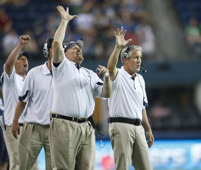 Dan Quinn, left, is rejoining the Seahawks and coach Pete Carroll, right. (Associated Press)