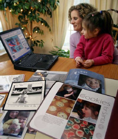 
Tiffany Brand and her daughter Alexandra look at pictures on their computer recently in Dover, N.H. Brand is joining thousands of people who are making the change to 