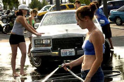 
Miranda Mayfield, right, and friends hold a fund-raising carwash. 
 (Holly Pickett / The Spokesman-Review)