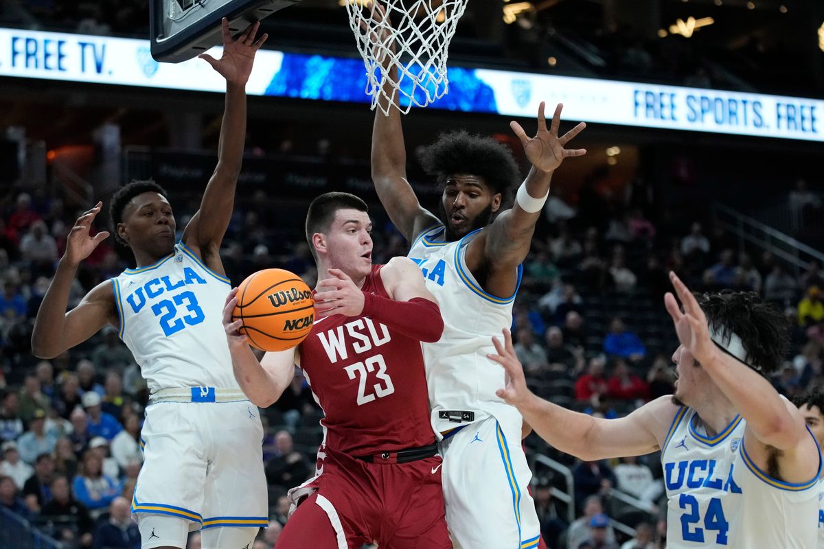 Washington State forward Andrej Jakimovski (23) passes around UCLA players during the first half of a Pac-12 Tournament quarterfinal on Thursday in Las Vegas.  (Associated Press)