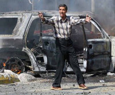 
An Iraqi man shouts for help to retrieve victims of a bombing attack from a destroyed vehicle in central Baghdad on Monday.
 (Reuters / The Spokesman-Review)