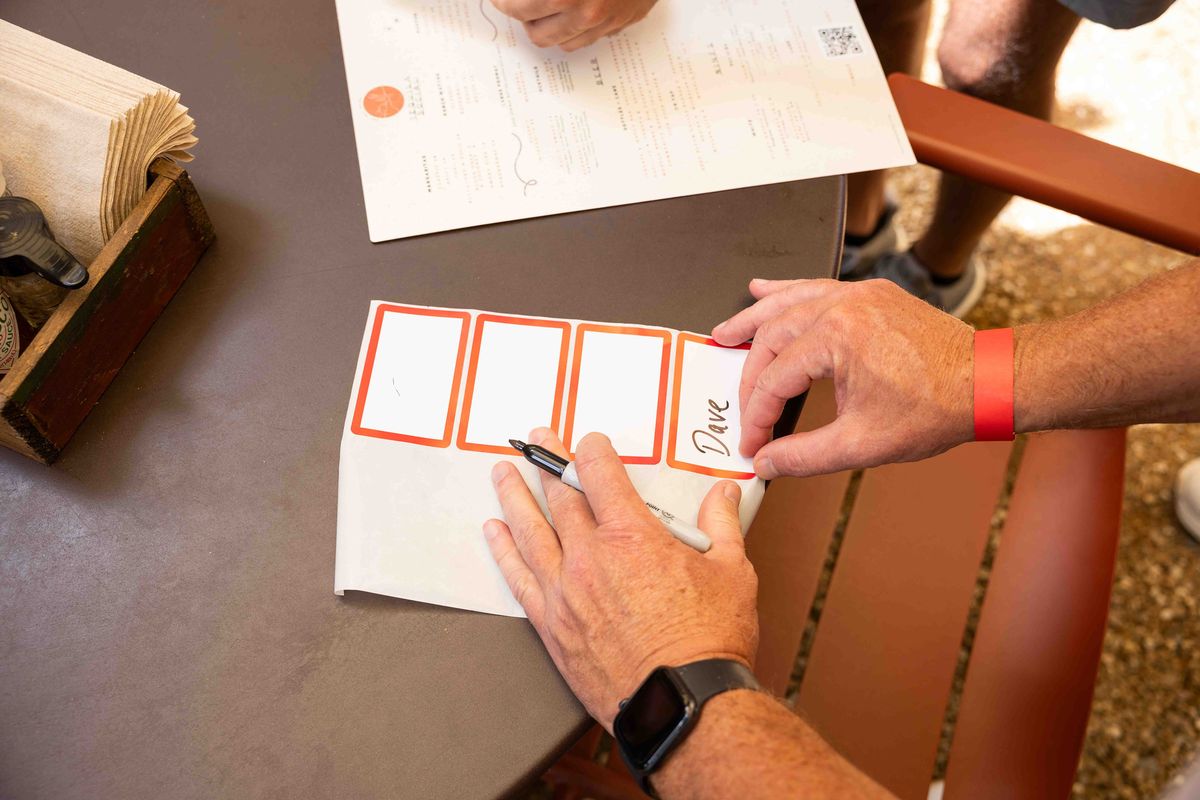 People write on their name tags during a Datey event in July. (Juan Figueroa/The Dallas Morning News/TNS)