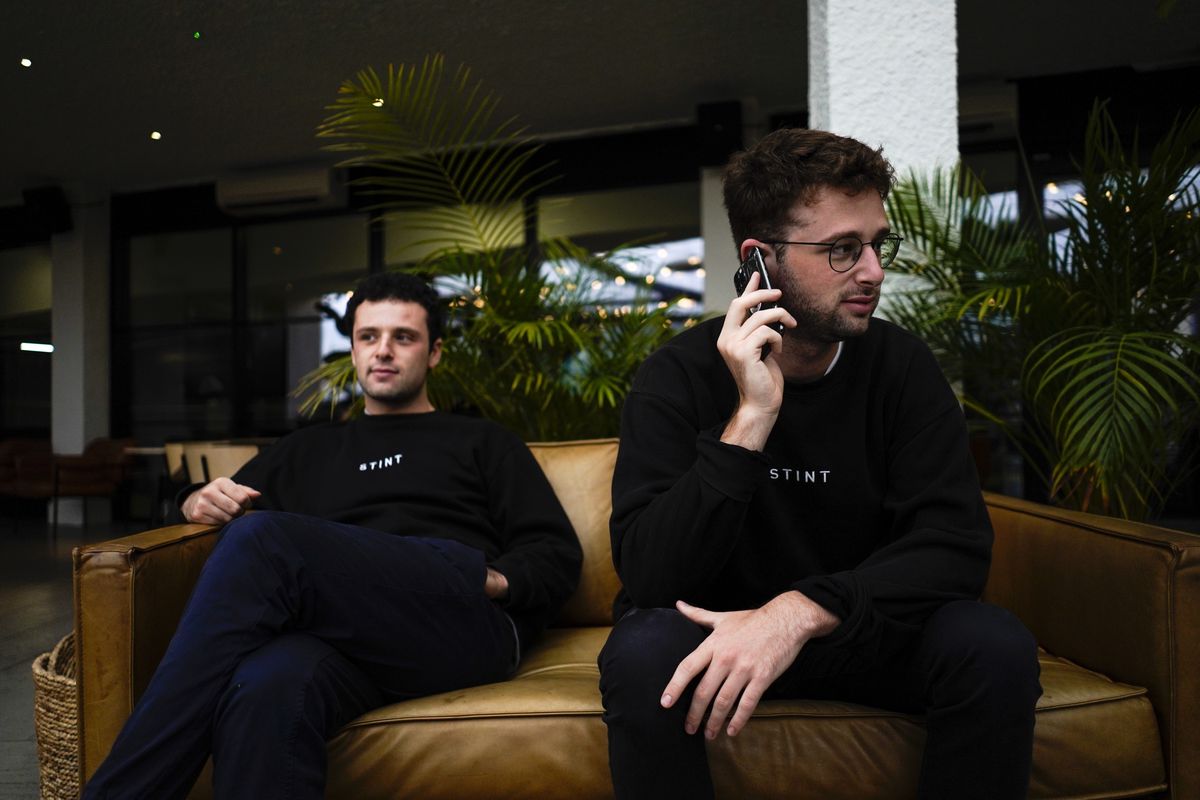 Co-founders of the app Stint, brothers Sam and Sol Schlagman, sit on a couch, at their headquarters in Camden, London, Monday, Aug. 23, 2021.   (Associated Press)
