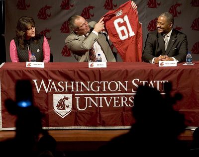 New Washington State University athletic director Bill Moos, center, holds up a copy of his old football jersey as WSU president Elson S. Floyd, right, and interim athletic director Anne McCoy, left, watch after Floyd introduced him at a news conference Wednesday, Feb. 24, 2010, in Pullman, Wash. (Dean Hare / Fr158448 Ap)