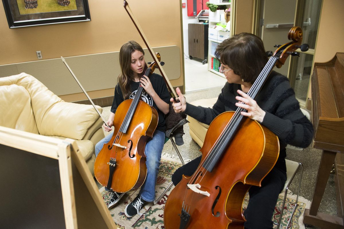 Janet Napoles, manager of education programs for the Spokane Symphony, works with Garfield Elementary student Abigail Connor, 11, before a Music Innovates after-school program rehearsal, March 2, 2016, at Garfield. (Colin Mulvany / The Spokesman-Review)