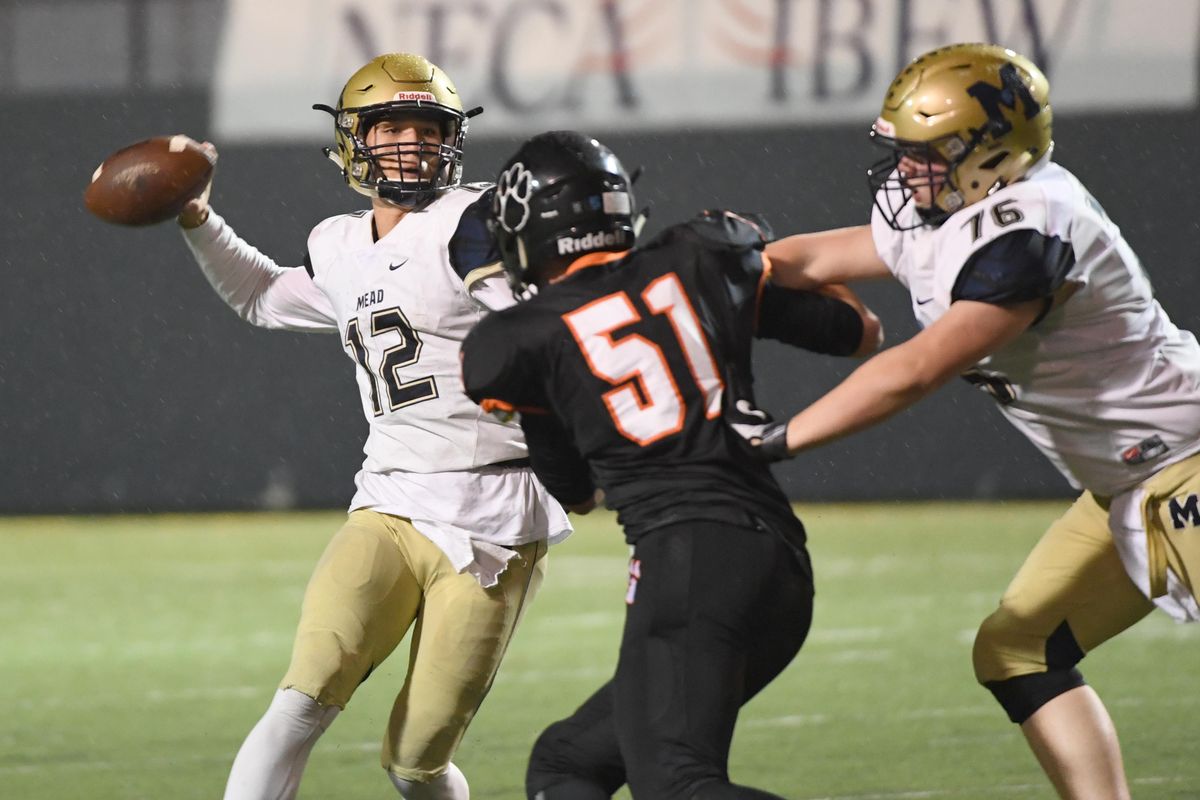 Mead quarterback Ray Chan, left, gets a pass away with Lewis and Clark