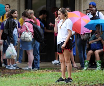 Students wait for buses to take them off campus in front of Evangeline Hall in Baton Rouge, La., Monday, Sept. 17, 2012 after an emergency text message was sent out due to a bomb threat. LSU said late Monday it has reopened its Baton Rouge campus and classes will resume Tuesday, a day after a bomb threat sparked a campus-wide evacuation. (Catherine Threlkeld / The Daily Reveille)