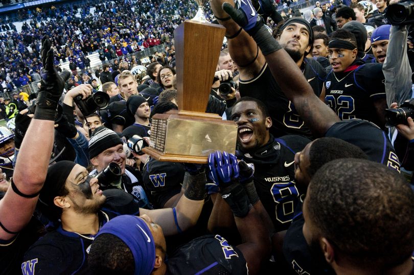 Washington reacts with the Apple Cup trophy after defeating Washington State during the second half of the 2013 Apple Cup on Friday, November 29, 2013, at Husky Stadium in Seattle, Wash. Washington won the game 27-17. (Tyler Tjomsland / The Spokesman-Review)