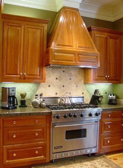 
Why not try installing a kitchen tile backsplash like this? The backsplash mirrors the angles of the vent hood, while smaller square decorative tiles display the colors of the granite countertops.
 (AP / The Spokesman-Review)