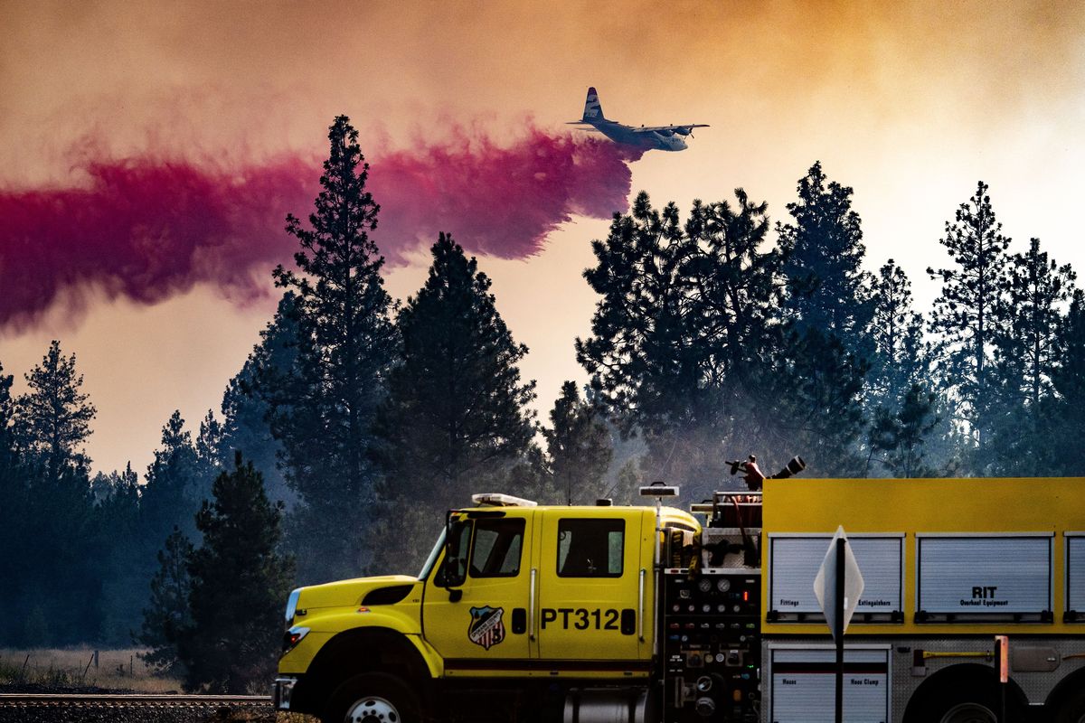 A firefighting aircraft drops fire retardant Friday on a wildfire southwest to Tyler, Wash.  (COLIN MULVANY/THE SPOKESMAN-REVI)