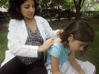 Dr. Anju Peters shows where a swarm of mosquitoes attacked her daughter Sonia, 7, leading last week to an outbreak of hives.
 (AP / The Spokesman-Review)