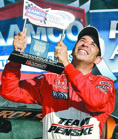 
Helio Castroneves lifts the trophy after winning the Indy 500 pole. 
 (Associated Press / The Spokesman-Review)