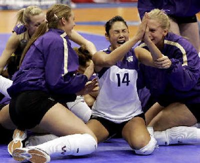 Candace Lee (14) kneels in joy as UW celebrates its volleyball title.
(Associated Press / The Spokesman-Review)