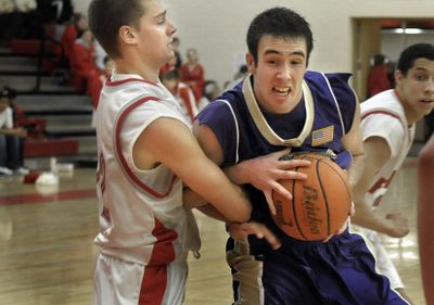 Jesse Vaughan of Rogers takes the ball into the lane against Ferris defender Jason Batesto. (Christopher Anderson / The Spokesman-Review)