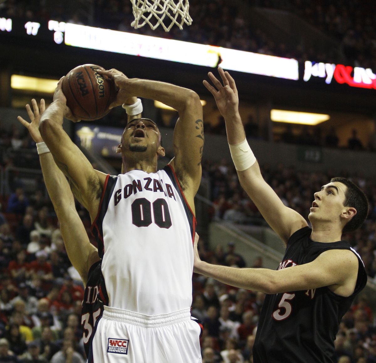 Davidson forward Dan Nelms fouls Gonzaga center Robert Sacre during the first half.  (Associated Press)