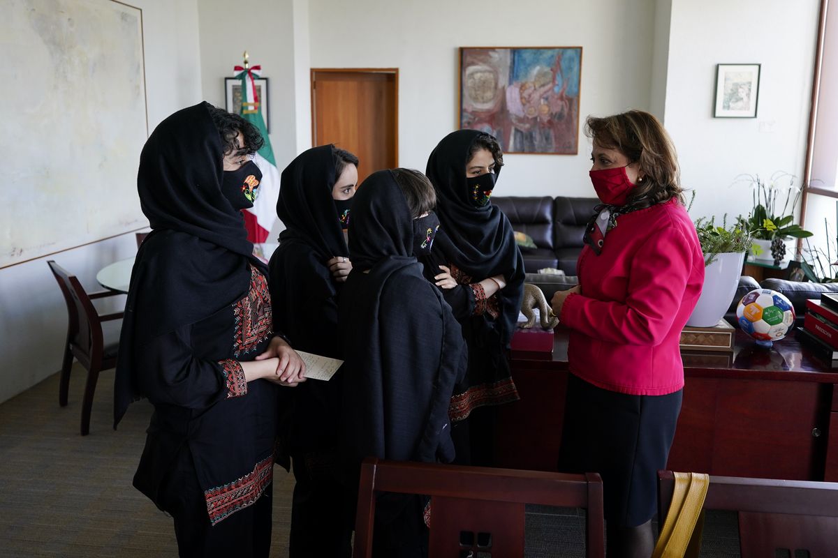 Martha Delgado, Undersecretary for Multilateral Affairs and Human Rights at the Ministry of Foreign Relations of Mexico, talks with members of the Afghan all-girls robotics team, after an interview in Mexico City, Wednesday, Aug. 25, 2021. After international efforts and coordination from a diverse group of volunteers to evacuate the team, the girls are begging the international community to help get their families to safety amid evacuations for people fleeing the Taliban takeover as the U.S. pulls out.  (Eduardo Verdugo)
