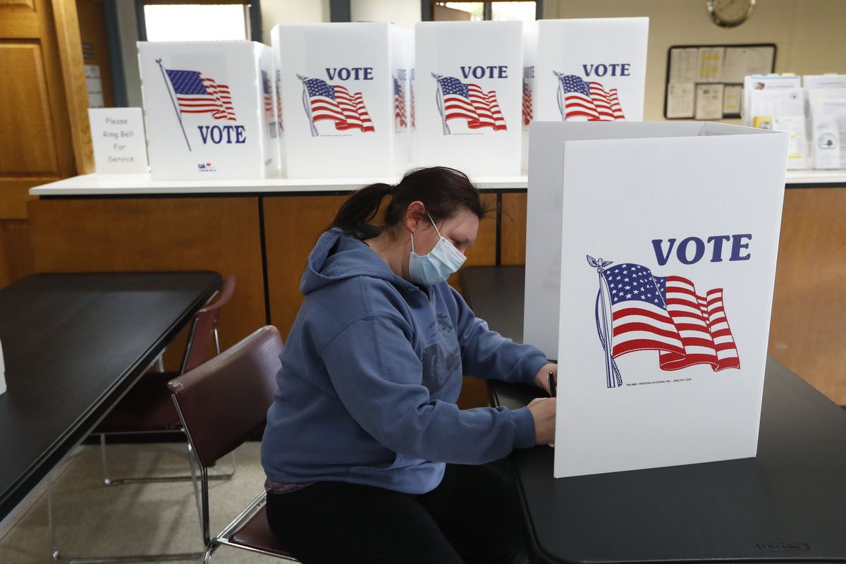 In this May 5, 2020 photo, Angela Beauchamp fills out an absentee ballot at City Hall in Garden City, Mich. This year, Republicans across the country have zeroed in on mail voting and enacted new limits on a process that exploded in popularity during the pandemic. (Paul Sancya)