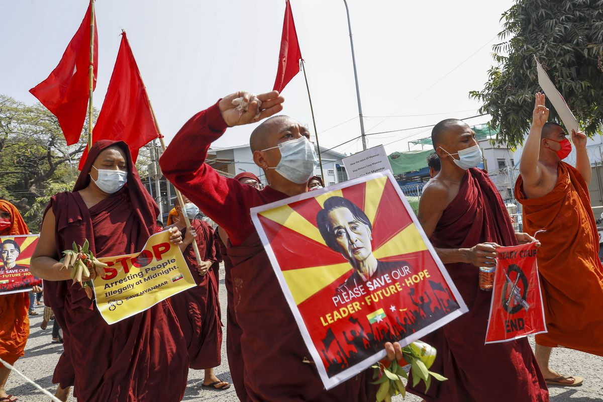 Buddhist monks and nuns display pictures of detained Myanmar leader Aung San Suu Kyi during a protest against the military coup in Mandalay, Myanmar on Tuesday, Feb. 16, 2021. Peaceful demonstrations against Myanmar’s military takeover resumed Tuesday, following violence against protesters a day earlier by security forces and after internet access was blocked for a second straight night.  (STR)