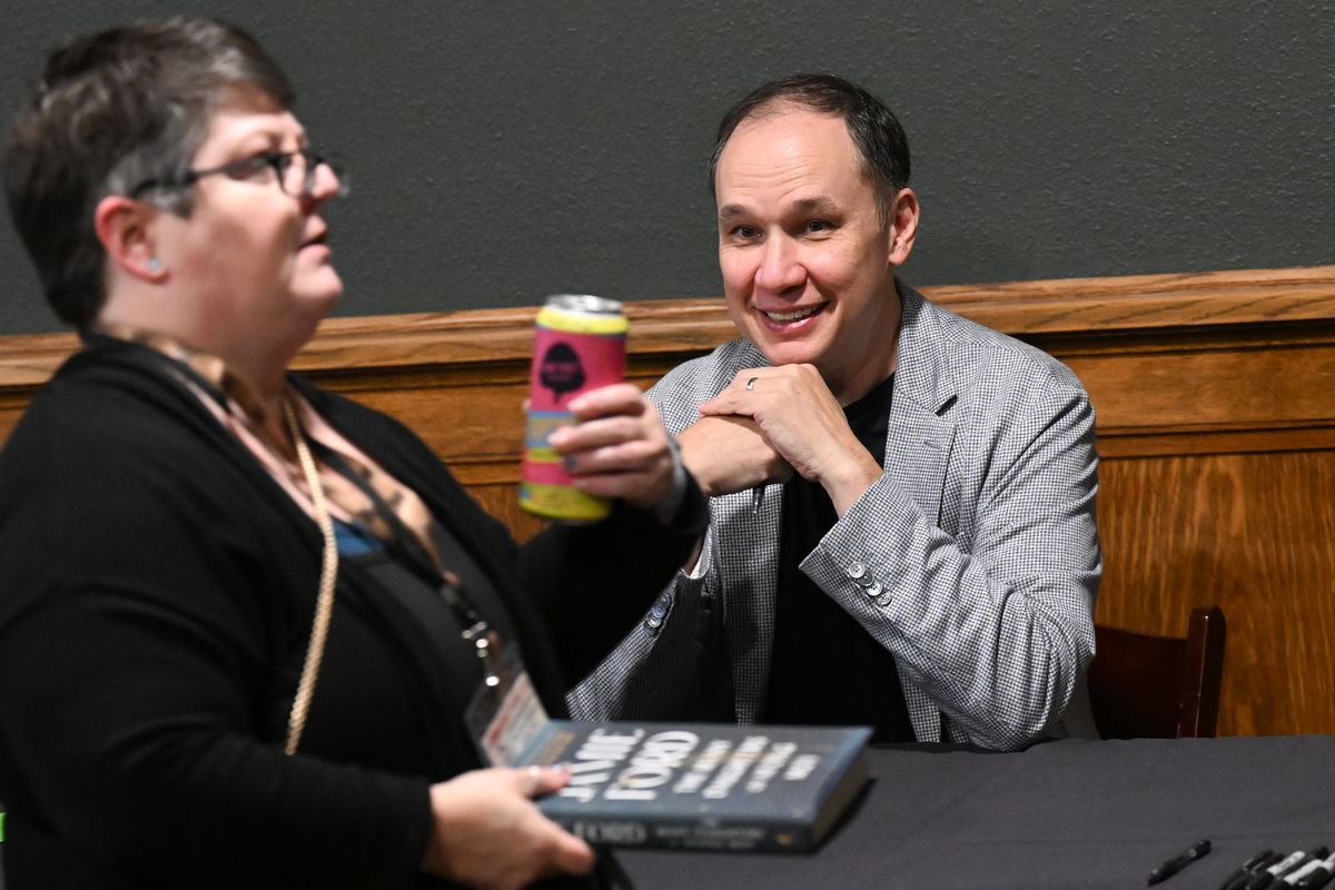 Jamie Ford, a New York Times bestselling author smiles while signing copies of his latest book “The Many Daughters of Afong Moy” on Wednesday during a Northwest Passages event held at the Montvale Event Center in Spokane.  (Tyler Tjomsland/The Spokesman-Review)