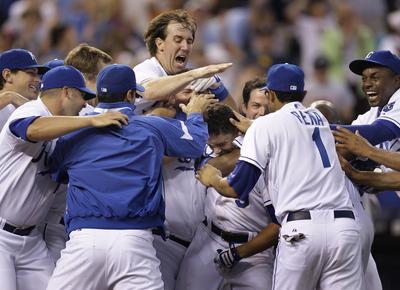 David DeJesus is swarmed by KC teammates. (Associated Press / The Spokesman-Review)