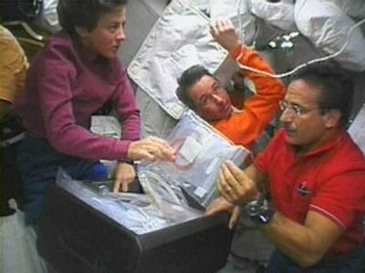 
Astronauts Wendy Lawrence, left, and Charles Camarda, right, stow equipment as astronaut Steve Robinson, center, floats in this view from television from the space shuttle Discovery's middeck Friday.
 (Associated Press / The Spokesman-Review)