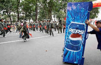 
A worker installs a Pepsi machine along a parade route as recruits practice marching in Ho Chi Minh City on Friday before Vietnam's celebration of the 30th anniversary of the end of the Vietnam War.
 (Associated Press / The Spokesman-Review)