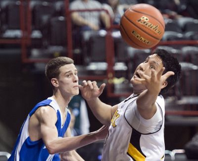 Cusick’s Franklin Pope, right, tries to corral a rebound against Seattle Lutheran’s Garret Ball during first-day action at the State 1B boys basketball tournament at Spokane Arena. Seattle Lutheran defeated Cusick 58-36. (Jesse Tinsley)