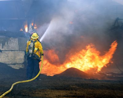 Firefighters work to put out a mulch pile at a nursery in Orange County, Calif., on Sunday. (Associated Press)
