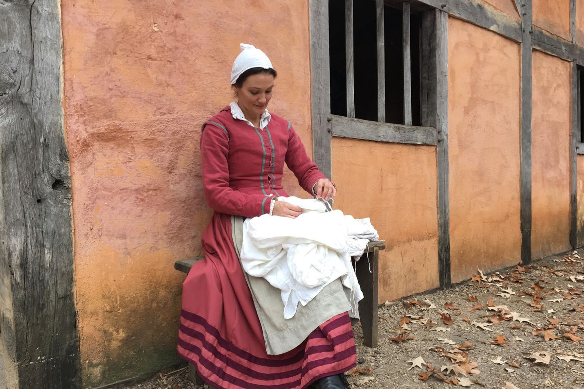 A Jamestown settlement historical interpreter sewing shirts in a re-created fort. (Jamestown-Yorktown Foundation / Jamestown-Yorktown Foundation photos)