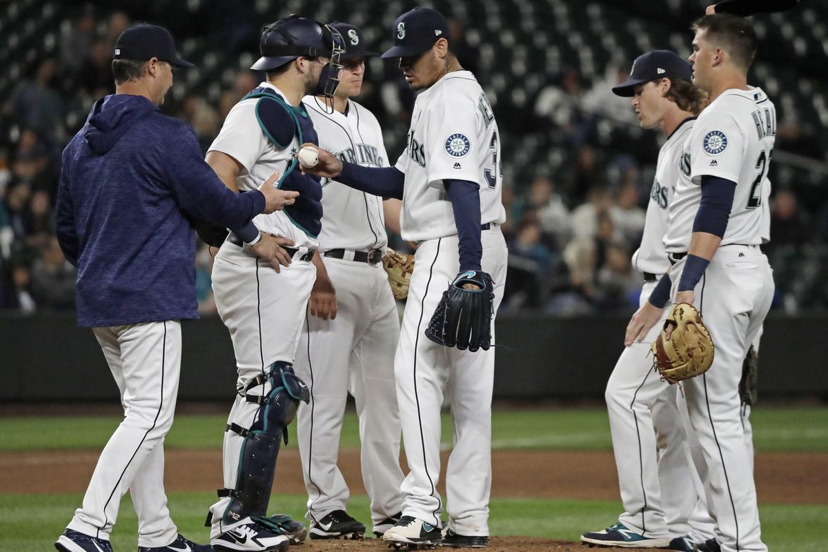 Seattle Mariners starting pitcher Felix Hernandez, center, is pulled from the baseball game against the Texas Rangers by manager Scott Servais, left, during the sixth inning Tuesday, May 29, 2018, in Seattle. (Ted S. Warren / AP)
