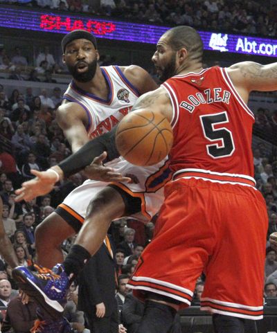 New York Knicks guard Baron Davis, left, passes the ball under the arm of Chicago Bulls forward Carlos Boozer. (Associated Press)