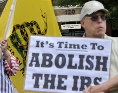 Cliff Toye, of Tabernacle, N.J., holds a sign as he stands with others Tuesday outside IRS offices in Cherry Hill, N.J. (Associated Press)