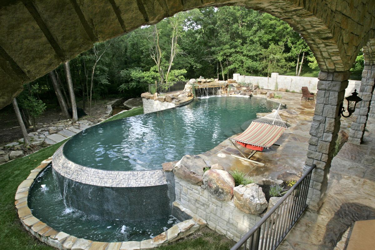 This saltwater pool made with natural stone and aggregate has LED lighting and special “green” inner workings. 