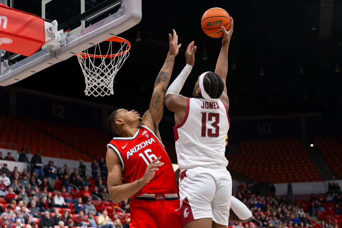 Washington State forward Isaac Jones, right, puts up a shot under pressure from Arizona forward Keshad Johnson in the first half on Saturday, Jan. 13, 2024, at Beasley Coliseum in Pullman, Wash.  (Geoff Crimmins/For The Spokesman-Review)