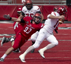 Eastern Washington University's DL Marcus Saugen (93) gets a hand on EWU's QB Gage Gubrud during the Red-White Game, April 25, 2015, in Cheney, Wash.  Gubrud escaped and completed a pass down field. (Dan Pelle / The Spokesman-Review)