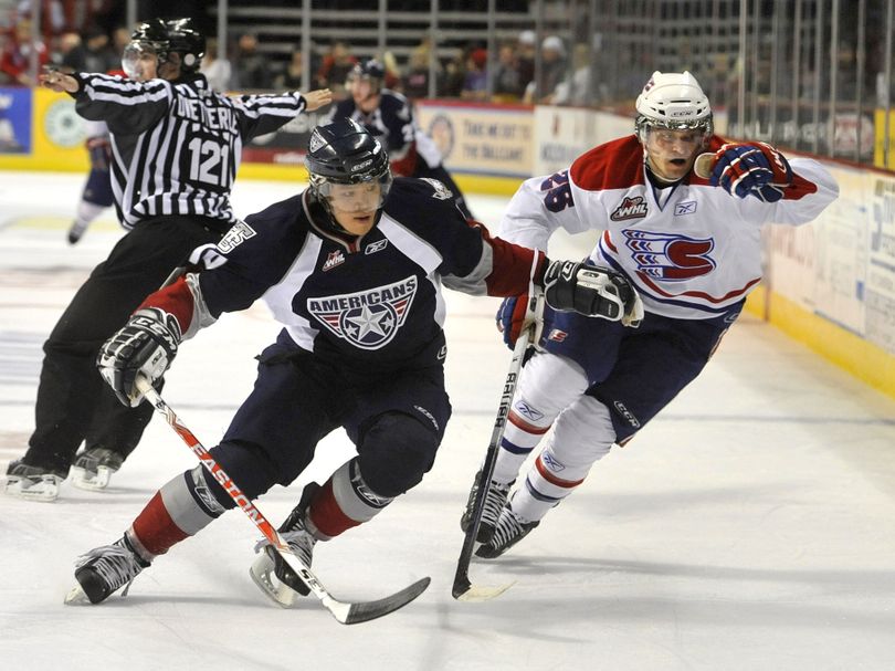 Chiefs Dominik Uher and Tri-City Zachary Yuen chase down the puck along the boards in the first period on Jan 29, 2011, in the Spokane Arena. (Dan Pelle / The Spokesman-Review)