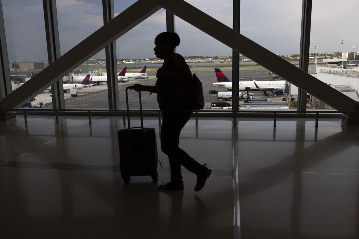 A passenger walks past Delta planes on the tarmac at LaGuardia Airport in New York.   (Angus Mordant/Bloomberg)