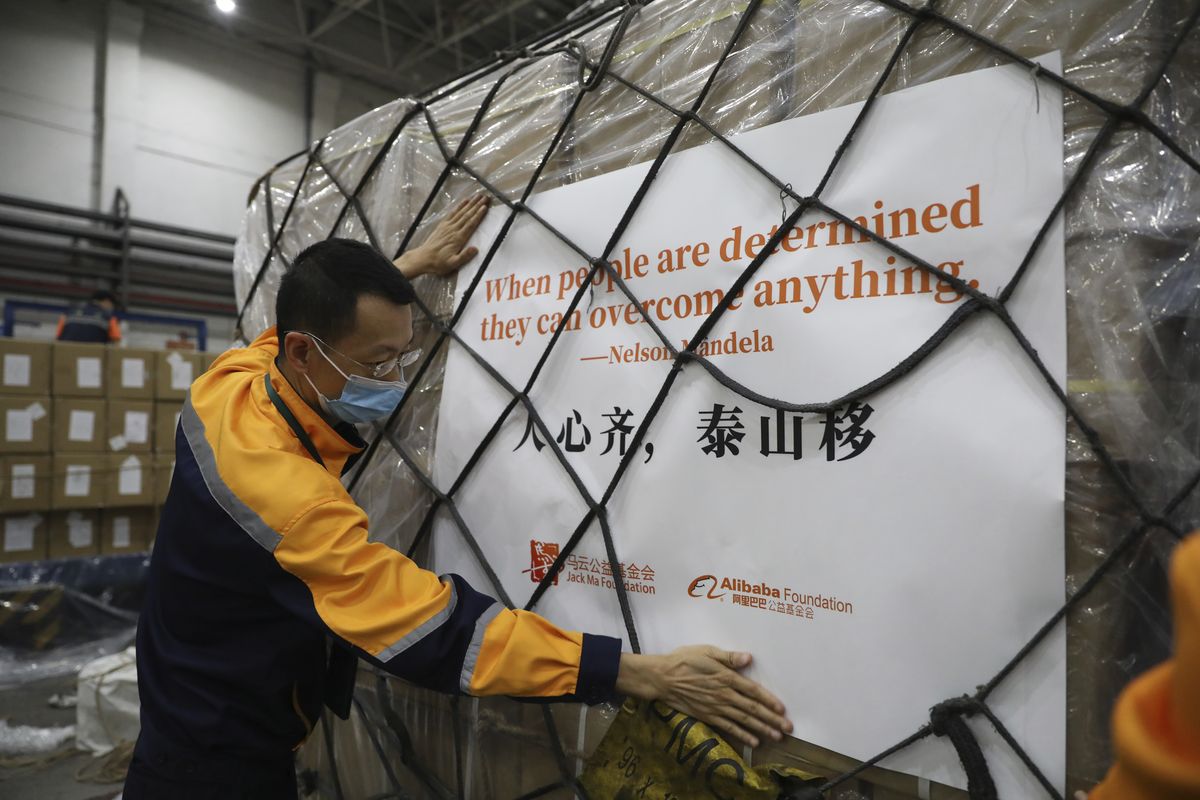 In this photo released by Alibaba Foundation, a worker prepares the first batch of donation from the Jack Ma Foundation and Alibaba Foundation bound for Africa to depart from Guangzhou in southern China