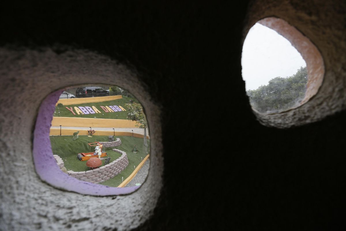 A photo taken Monday, April 1, 2019, shows the view from windows from a stairway to an upstairs bedroom looking out to the front yard of the Flintstone House in Hillsborough, Calif. The San Francisco Bay Area suburb of Hillsborough is suing the owner of the house, saying that she installed dangerous steps, dinosaurs and other Flintstone-themed figurines without necessary permits. The owner and her attorney say they will fight for the rights of property owners. (Eric Risberg / Associated Press)