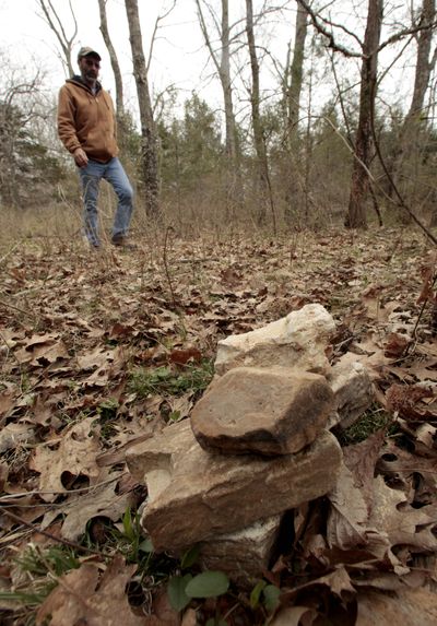 Andy Justice walks to a pile of rocks on land he farms east of Plato, Mo., on Thursday. The rocks were placed there by a government survey crew to mark the population center of the United States. (Associated Press)